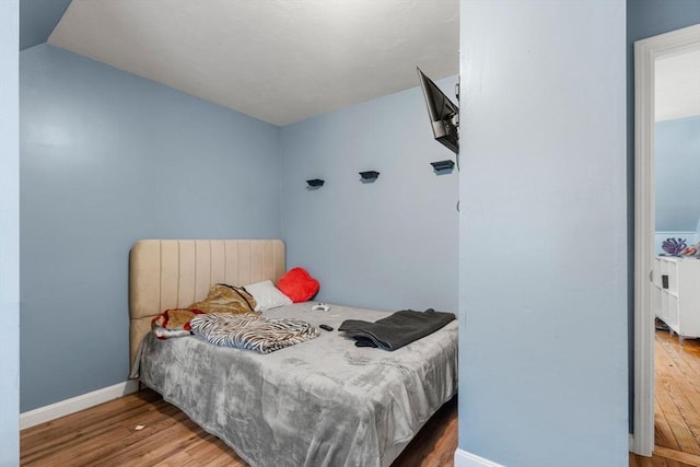 bedroom with baseboards and wood finished floors