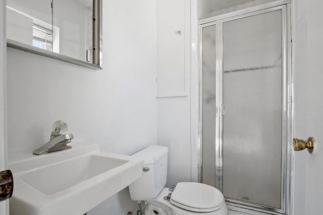 bathroom with sink, an enclosed shower, and toilet