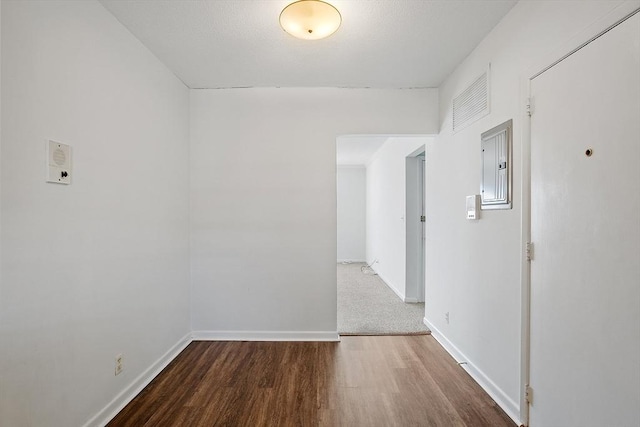 spare room featuring electric panel and hardwood / wood-style floors