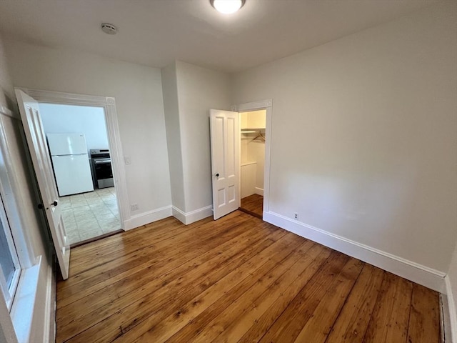 98 Boylston St Unit 1, Brookline, MA 02445 - unfurnished bedroom featuring freestanding refrigerator, baseboards, light wood-style floors, and a closet
