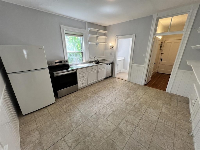 98 Boylston St Unit 1, Brookline, MA 02445 - kitchen featuring stainless steel appliances, a sink, wainscoting, white cabinetry, and light countertops