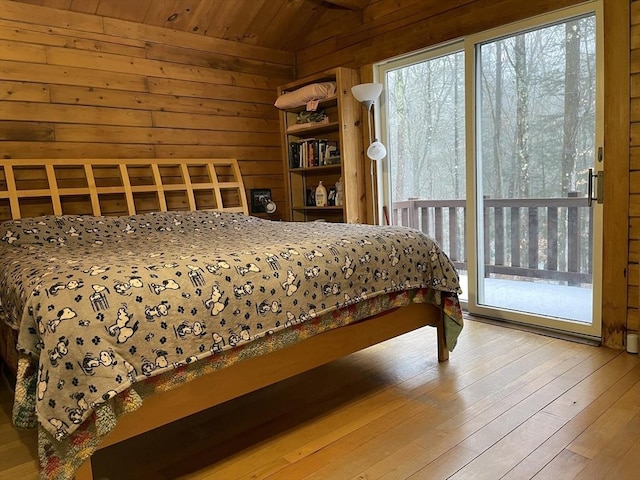 bedroom featuring lofted ceiling, wooden ceiling, access to outside, wooden walls, and hardwood / wood-style flooring