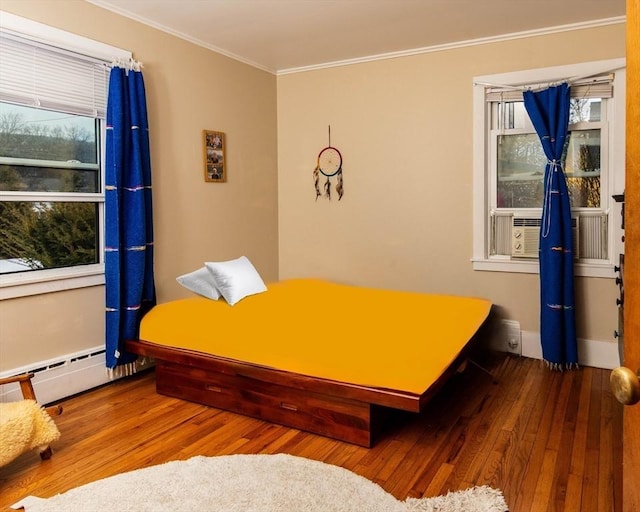 bedroom featuring cooling unit, ornamental molding, baseboard heating, and wood finished floors