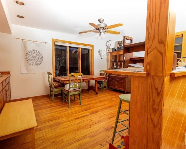 dining area with light wood-type flooring, ceiling fan, and baseboards