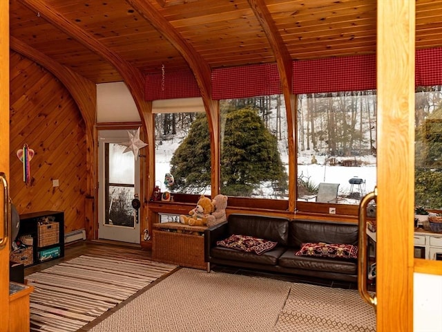 sunroom / solarium featuring vaulted ceiling with beams, baseboard heating, and wood ceiling