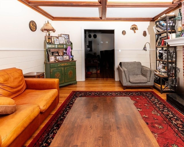 unfurnished living room featuring ornamental molding, wainscoting, and wood finished floors