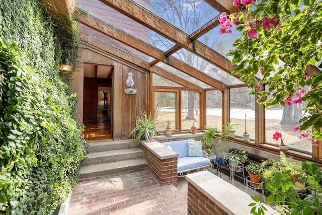 unfurnished sunroom featuring lofted ceiling and a healthy amount of sunlight