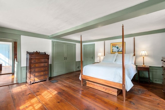 bedroom with a wainscoted wall and hardwood / wood-style floors