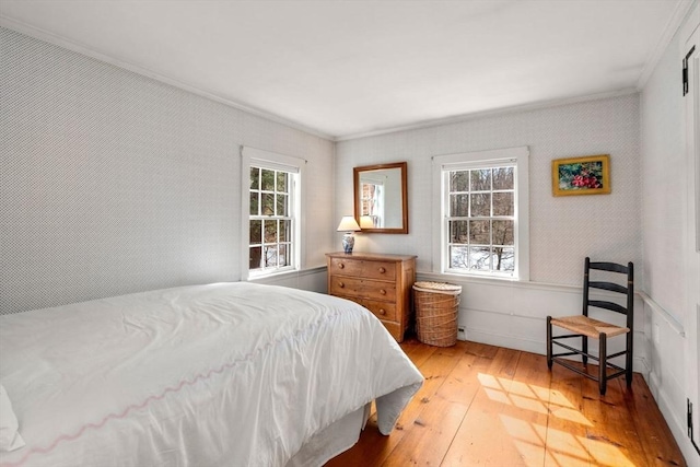 bedroom featuring wallpapered walls, light wood-style flooring, and crown molding