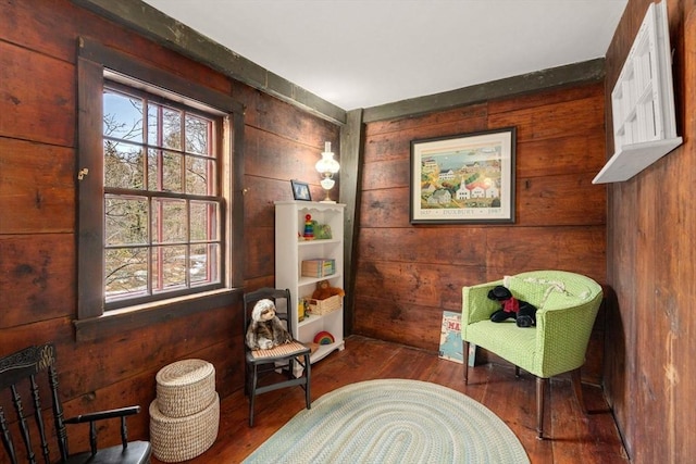 sitting room with wood walls and wood finished floors