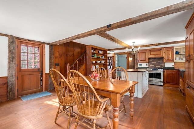 dining space featuring hardwood / wood-style flooring, a notable chandelier, stairs, and beamed ceiling