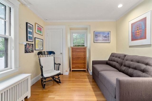24 Aspen Ave, Newton, MA 02466 - living area with radiator heating unit, light wood-style flooring, crown molding, and recessed lighting