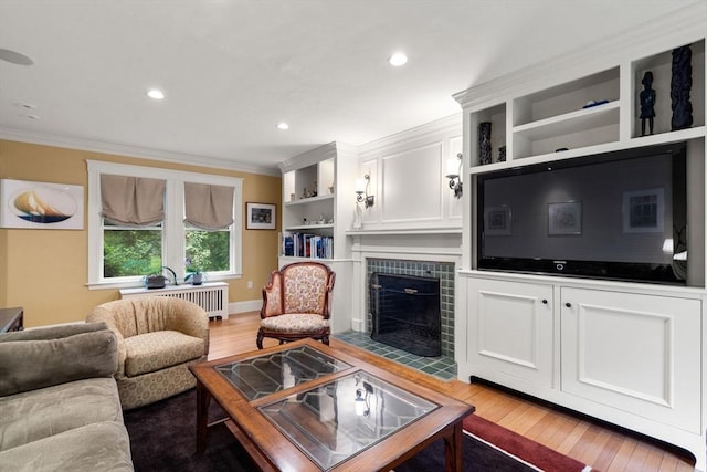 24 Aspen Ave, Newton, MA 02466 - living room featuring crown molding, radiator, light wood-style flooring, a tiled fireplace, and recessed lighting