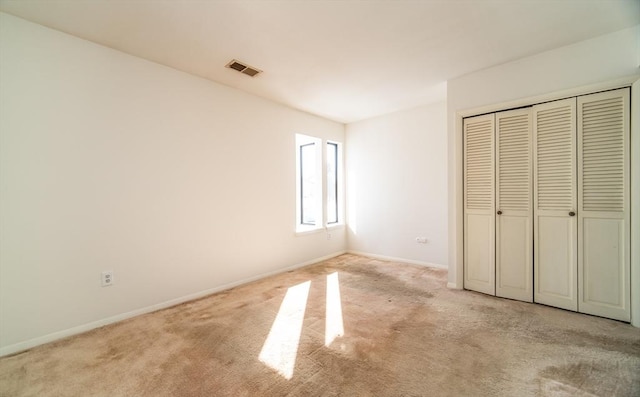 unfurnished bedroom featuring carpet floors, a closet, visible vents, and baseboards