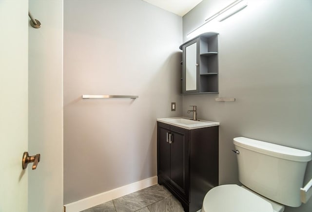 bathroom featuring vanity, toilet, and baseboards