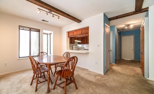 dining space with light carpet, baseboards, visible vents, and beam ceiling