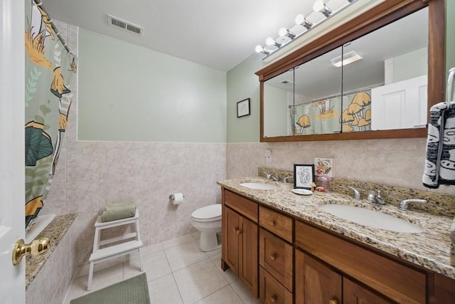 239 Prospect St Unit 2, Cambridge, MA 02139 - full bathroom featuring tile walls, tile patterned floors, curtained shower, toilet, and double vanity