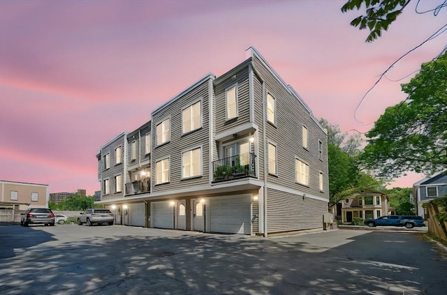 239 Prospect St Unit 2, Cambridge, MA 02139 - property at dusk featuring asphalt driveway and an attached garage