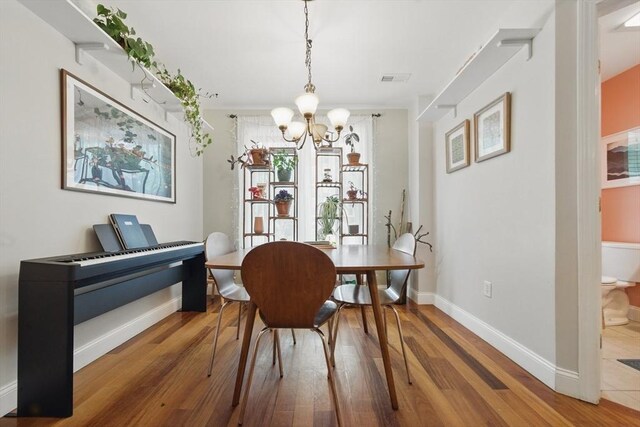 239 Prospect St Unit 2, Cambridge, MA 02139 - dining room featuring a chandelier, wood finished floors, and baseboards
