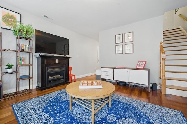 239 Prospect St Unit 2, Cambridge, MA 02139 - living room with wood finished floors, stairway, a glass covered fireplace, and baseboards