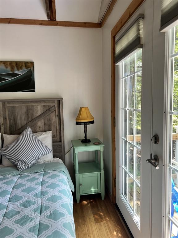 10 Kibbe Point Rd, Otis, MA 01253 - bedroom featuring wood finished floors, beam ceiling, and access to exterior