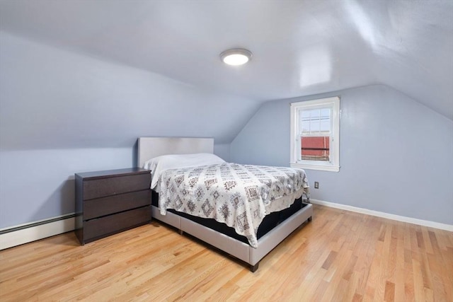 bedroom featuring lofted ceiling, light wood-type flooring, and baseboard heating