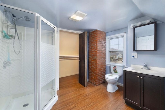 bathroom featuring toilet, wood-type flooring, vaulted ceiling, vanity, and a shower with door