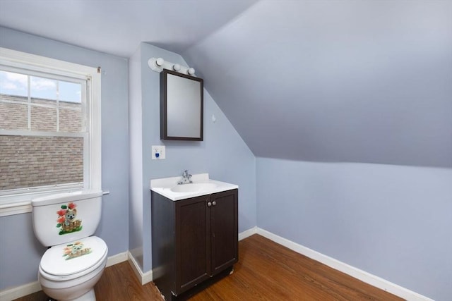 bathroom with lofted ceiling, vanity, wood-type flooring, and toilet