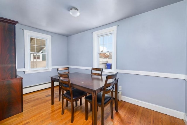 dining space featuring a baseboard radiator and light hardwood / wood-style flooring