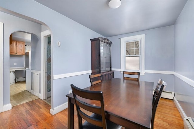 dining room with a baseboard heating unit and light hardwood / wood-style floors