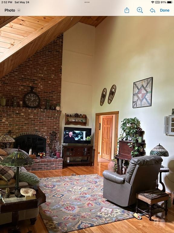 210 Wales Rd, Monson, MA 01057 - living area with wood finished floors, high vaulted ceiling, wooden ceiling, and a fireplace