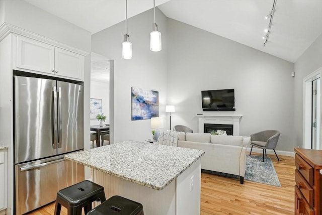 83 Partridge Hill Rd, Sutton, MA 01590 - kitchen with freestanding refrigerator, rail lighting, light wood-type flooring, a center island, and light stone countertops