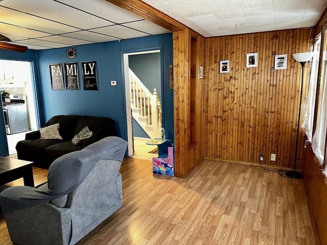 living room with wood walls and light wood-type flooring