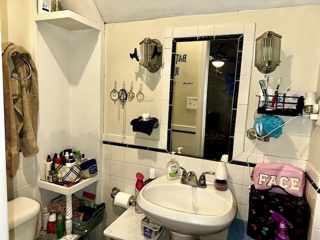 bathroom with sink, tile walls, backsplash, and toilet