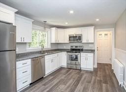 kitchen with radiator, white cabinetry, dark wood-type flooring, and appliances with stainless steel finishes