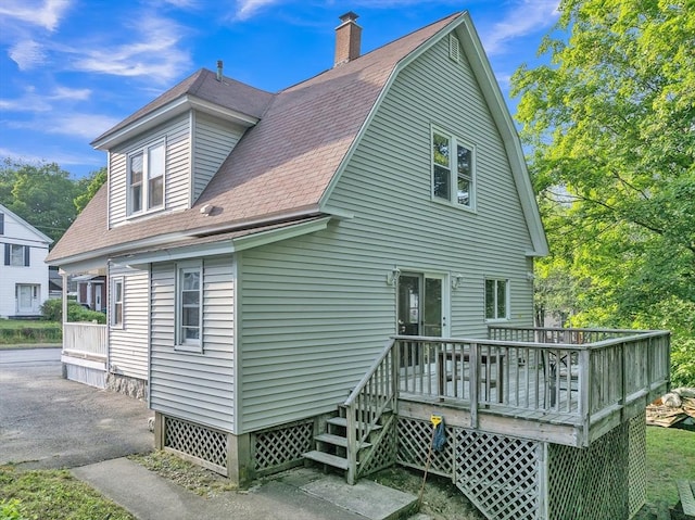 484 Rollstone St, Fitchburg, MA 01420 - back of property with a wooden deck, a chimney, a shingled roof, and a gambrel roof