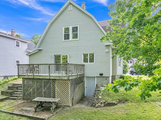 484 Rollstone St, Fitchburg, MA 01420 - back of property with a deck, stairs, a chimney, and a gambrel roof