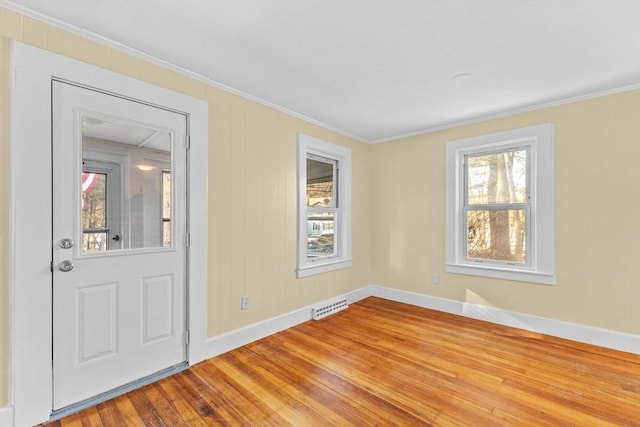 foyer entrance with ornamental molding and hardwood / wood-style floors