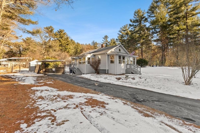 view of snow covered exterior with a carport