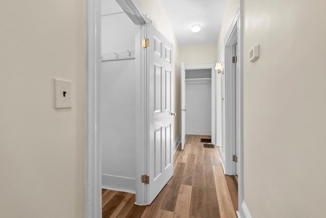 hall featuring wood finished floors and baseboards