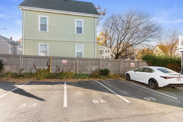 uncovered parking lot with a fenced front yard