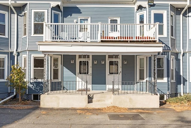 view of property featuring a porch and a balcony