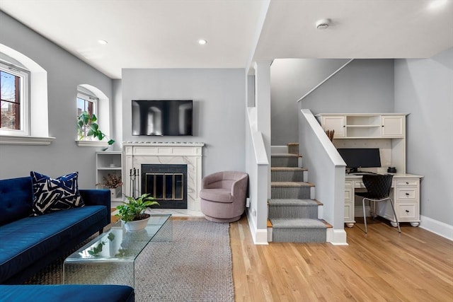 120 Norway St Unit 12, Boston, MA 02115 - living room with light wood finished floors, stairway, a high end fireplace, baseboards, and a desk