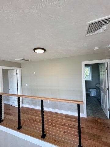 bar featuring dark wood-type flooring and a textured ceiling