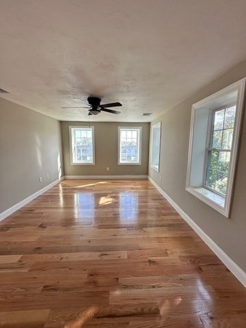 unfurnished room with ceiling fan, a healthy amount of sunlight, and light hardwood / wood-style flooring