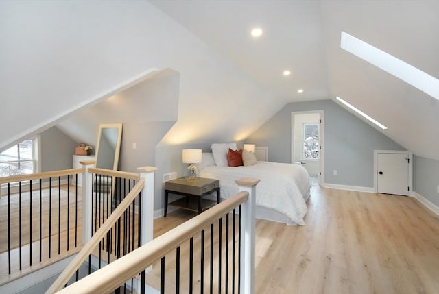 bedroom with visible vents, baseboards, lofted ceiling with skylight, wood finished floors, and recessed lighting