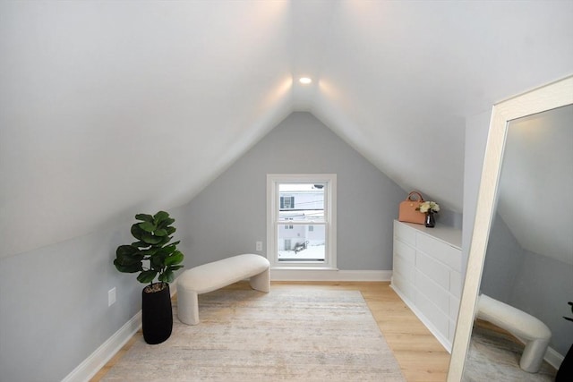 bonus room featuring lofted ceiling, light wood-style floors, and baseboards