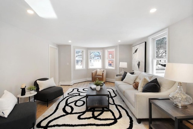 living area with baseboards, light wood-style flooring, and recessed lighting