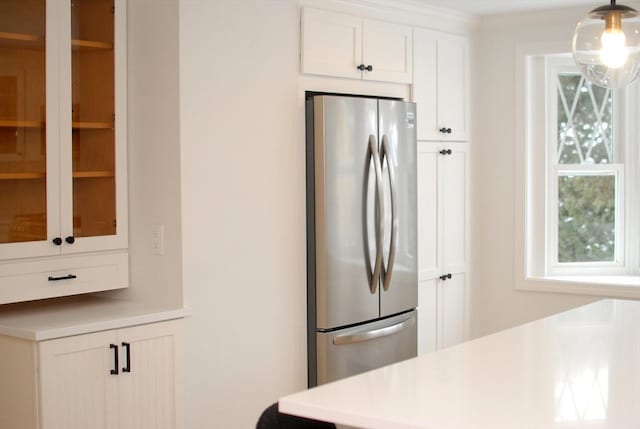 kitchen featuring freestanding refrigerator, white cabinets, and light countertops