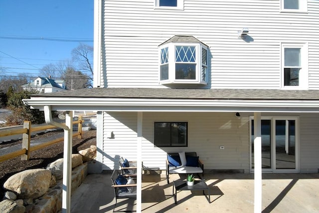 back of property featuring a patio, a shingled roof, and fence